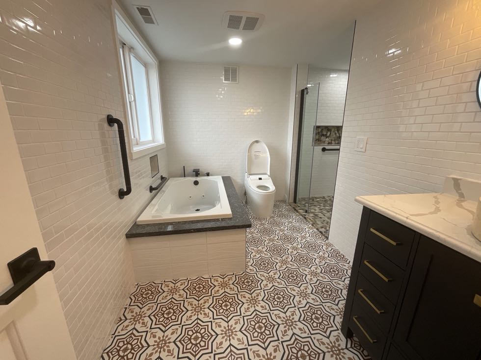Master bathroom with soaking tub and patterned tile floor